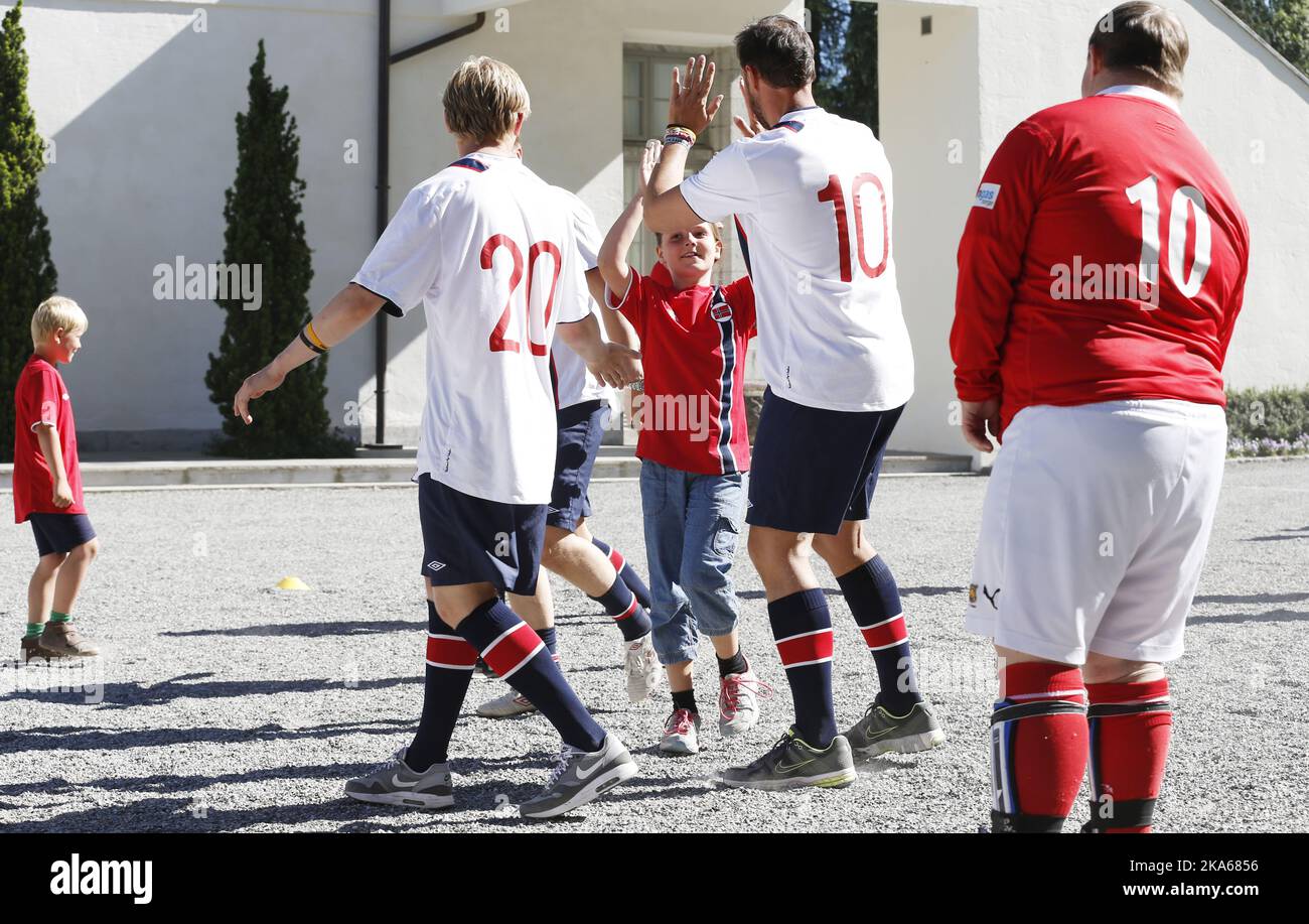 Asker, Norvège 20140616. L'Association norvégienne de football et le Crownprincecouple norvégien, la Crownprincesse mette-Marit et le Crownprince Haakon ont organisé un match de football de charité dans leur résidence Skaugum à Asker, au sud d'Oslo, lundi 16 juin 2014. Le terrain a été appelé 'Stade de Shaugum' pour l'occasion. La photo montre la princesse Ingrid Alexandra donnant à son père Crownprince Haakon un "cinq haut", ou peut-être même un "dix haut". Photo: Cornelius Poppe / NTB scanpix Banque D'Images