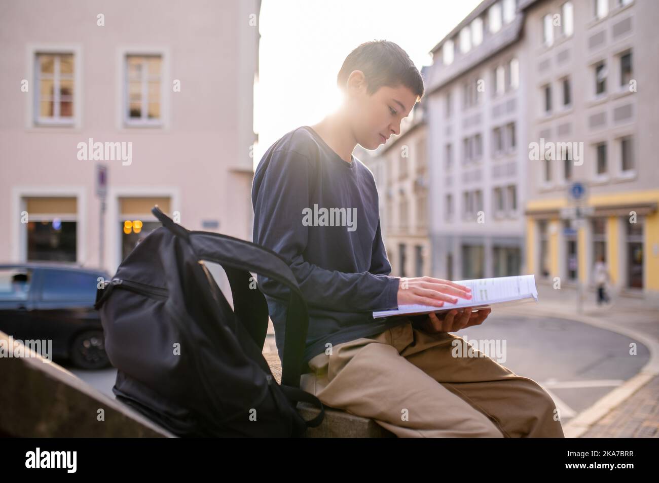 Adolescent assis sur la balustrade impliqué dans la lecture Banque D'Images
