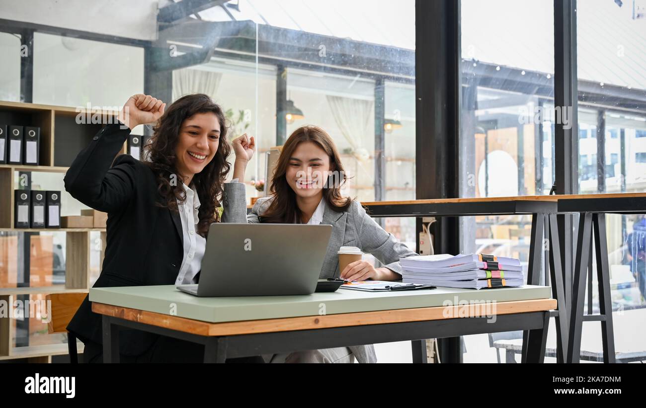 Deux femmes d'affaires caucasiennes millénaires heureuses et gaies célèbrent leur projet approuvé, obtenant un bon résultat de campagne, partageant de bons moments Banque D'Images