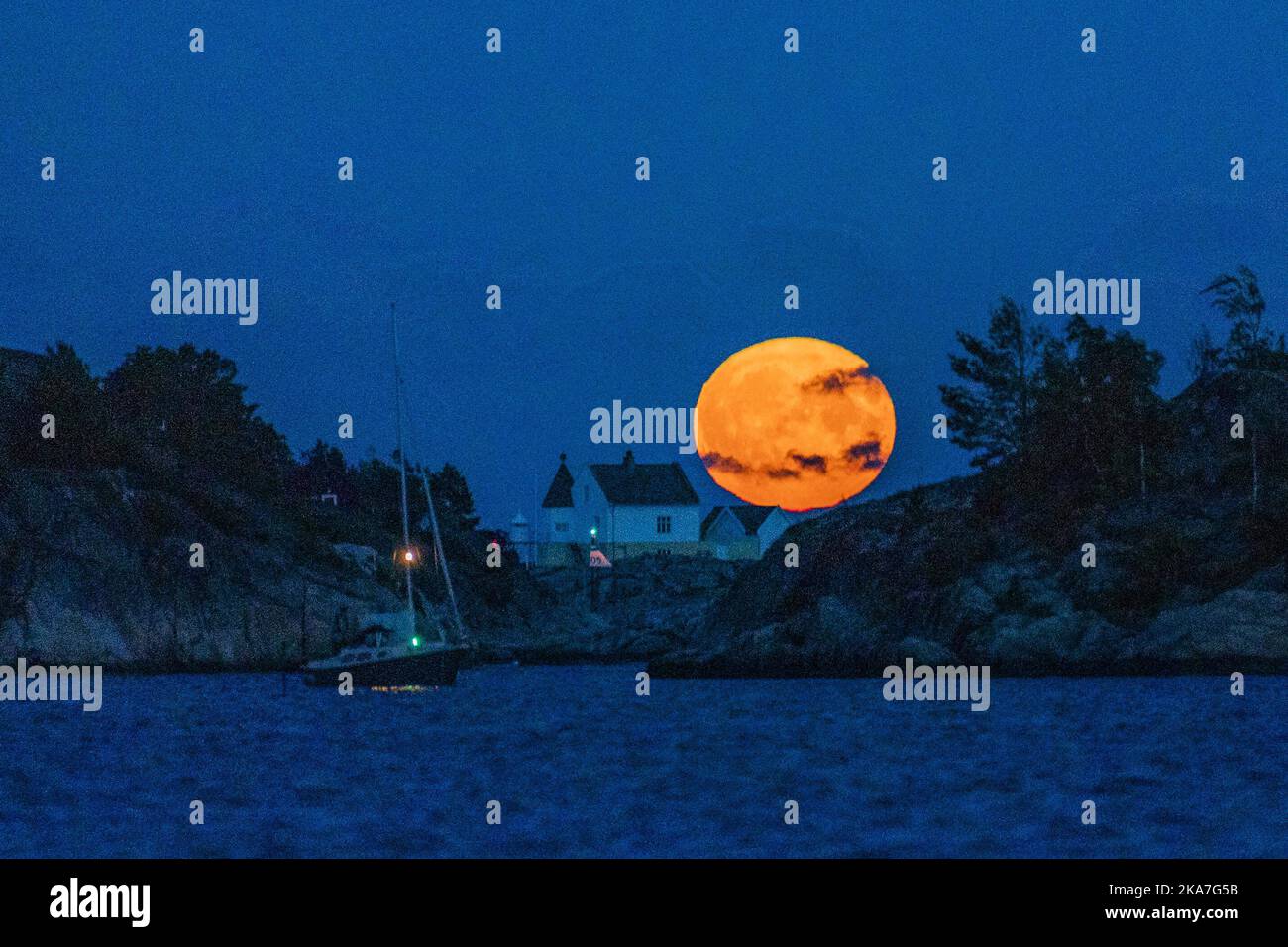 Lillesand 20220713. La pleine lune s'élève de la mer au phare de Saltholmen à l'extérieur de Lillesand tard le mercredi soir. C'est la dernière superlune de l'année. Une superlune se produit lorsqu'il y a une pleine lune en même temps que la lune est à son point le plus proche de la terre. La prochaine fois que nous aurons l'expérience de la superlune, c'est 1 août 2023. Photo: Haakon Mosvold Larsen / NTB Banque D'Images