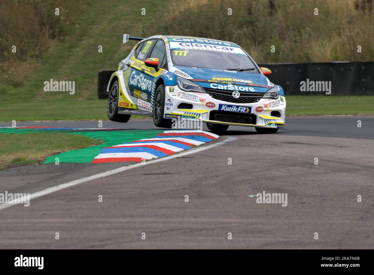 Michael Crees numéro 777 survolant le virage sur le circuit de course de Thruxton en 2022 dans sa voiture de course Carstore Power en boîte dans le BTCC Banque D'Images