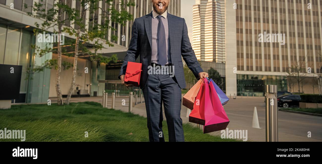 coupe réussie homme en tenue de cérémonie avec sacs de shopping et boîte de  cadeau à l'extérieur du bureau, bonus Photo Stock - Alamy