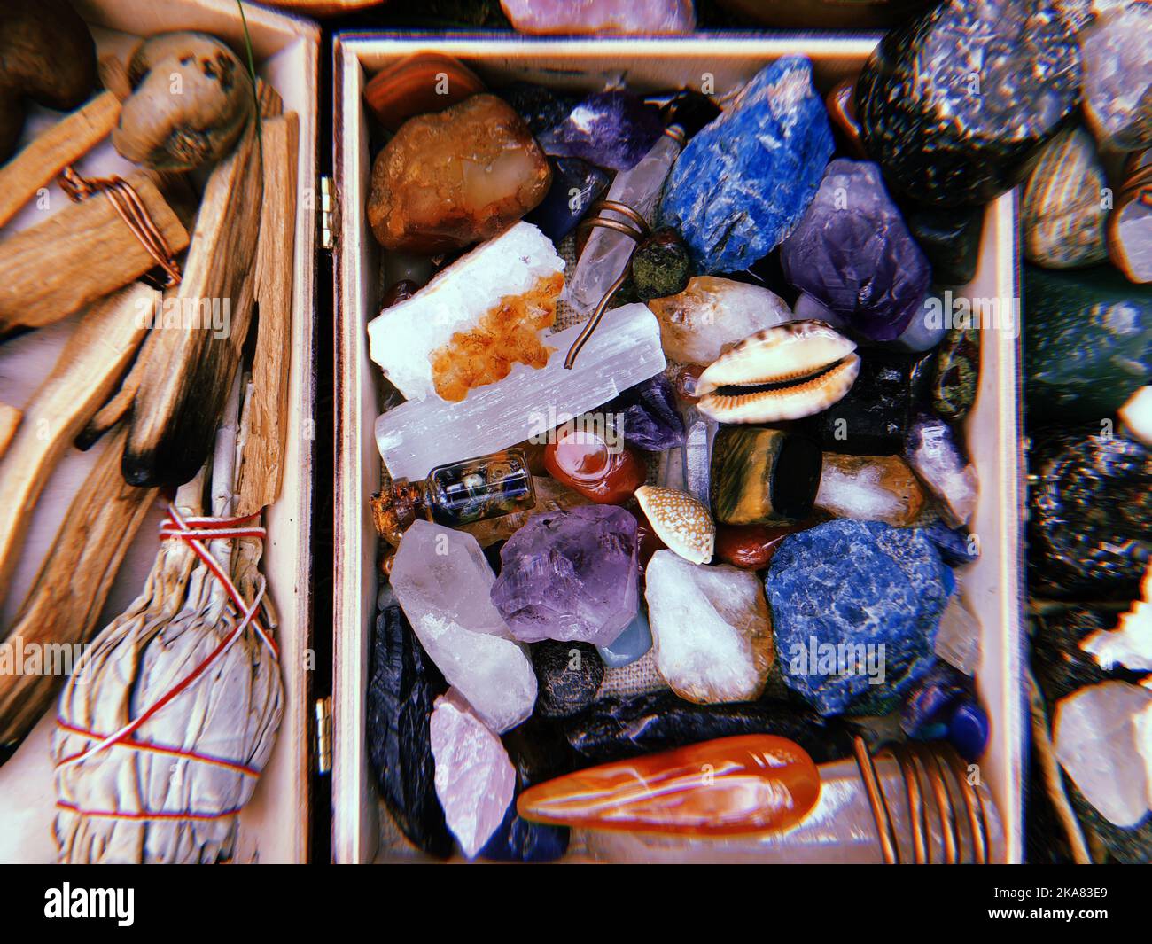 Une vue de dessus des bâtonnets de Palo Santo et des pierres de guérison en cristal colorées dans une boîte pour la méditation Banque D'Images