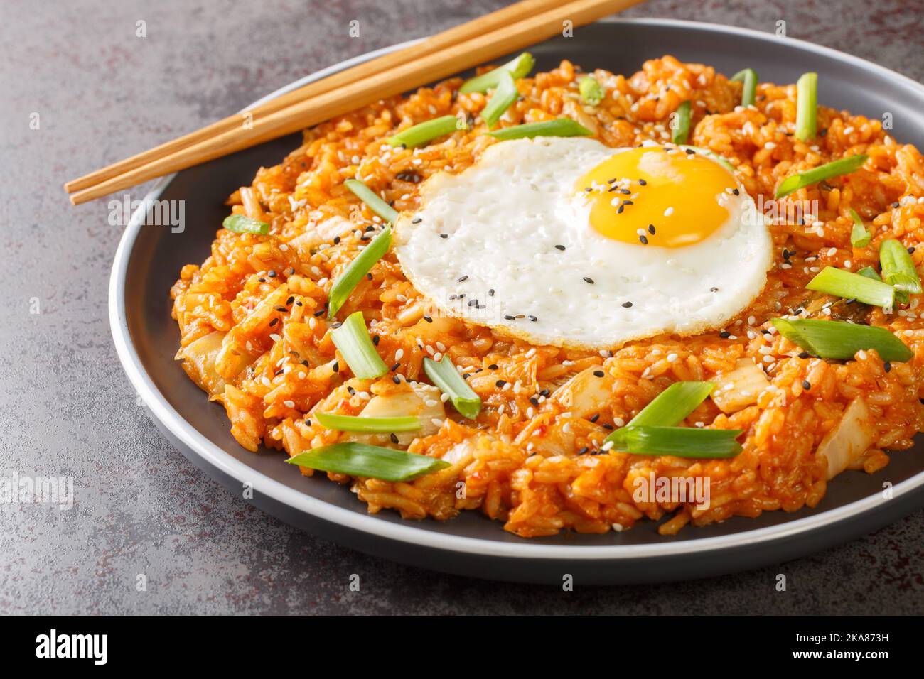 Riz frit aux kimchi faits maison recouvert d'œufs frits sur l'assiette de la table. Horizontale Banque D'Images