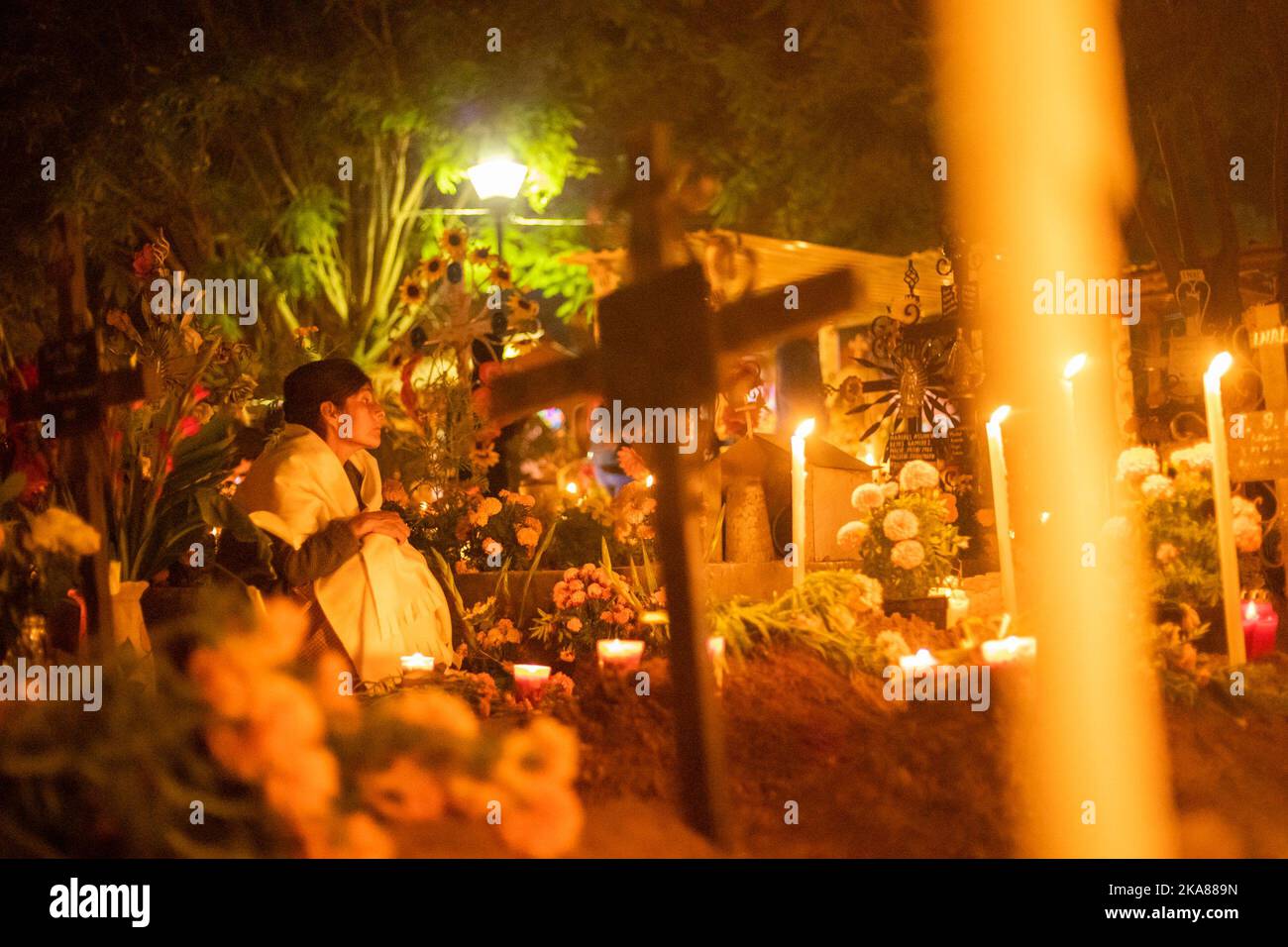 Oaxaca, Mexique. 31st octobre 2022. Une femme est assise à une tombe dans un cimetière éclairé et décoré de bougies. Chaque année sur 1 novembre, les habitants des communautés d'Oaxaca se rendent dans les cimetières pour tenir le réveil traditionnel aux tombes de leurs proches. Le jour de la Toussaint et de la Toussaint, le Mexique célèbre le jour des morts (Día de Muertos). Comme dans d'autres régions catholiques du monde, les morts sont commémorés - généralement à la tombe de parents décédés. Credit: Felipe Perez/dpa/Alay Live News Banque D'Images