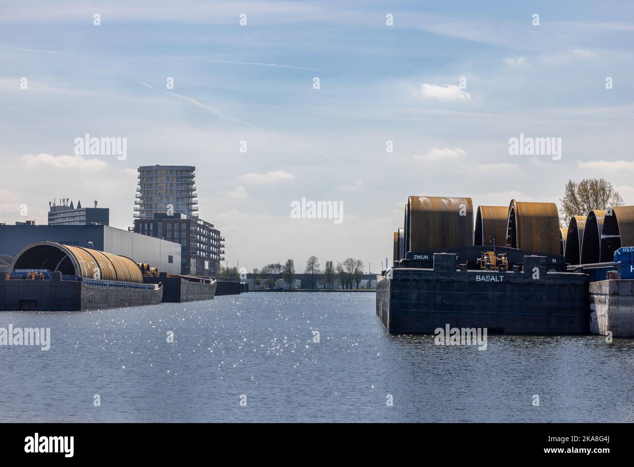 Un gros plan de barges avec des monopiles dans un port industriel de Roermond Banque D'Images