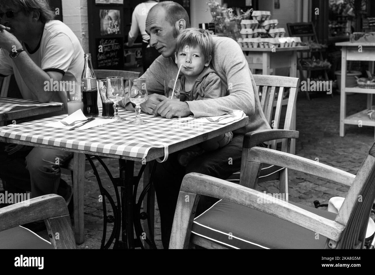 Adulte et enfant dans un café en France. Banque D'Images