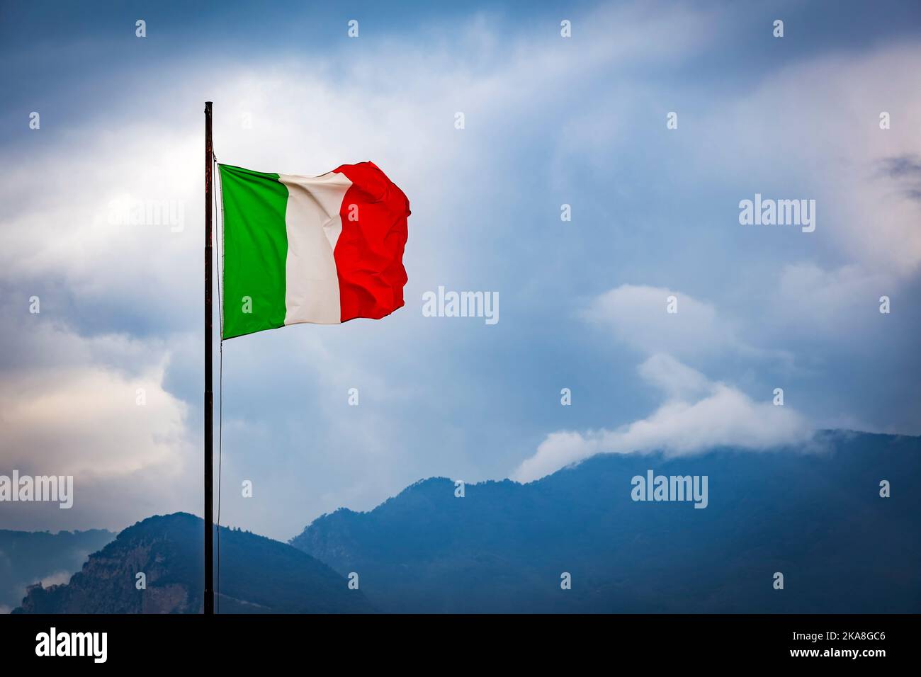 Drapeau national italien sur fond de ciel et de collines Banque D'Images