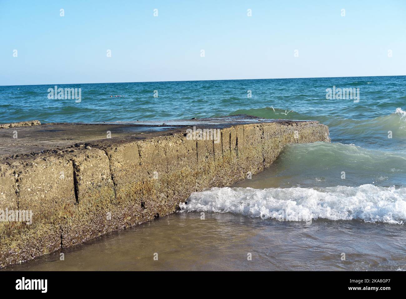 Vagues heurtant des pierres d'un ancien quai Banque D'Images