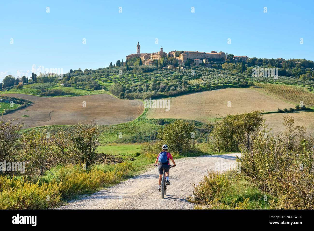 Belle femme senior à cheval sur son vélo électrique de montagne dans la  région de Ghianti, contemplez l'horizon de la ville médiévale de Pienza ,  Toscane , Italie Photo Stock - Alamy