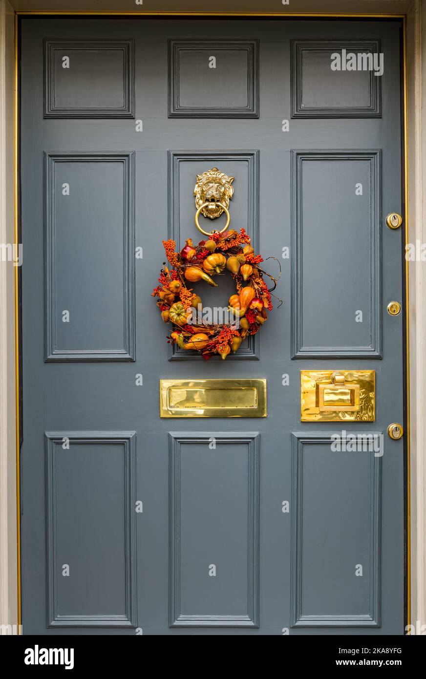 Couronne de récolte saisonnière sur la porte avant à panneaux géorgiens ; boîte aux lettres et knocker en laiton, Edinburgh New Town, Écosse, Royaume-Uni Banque D'Images
