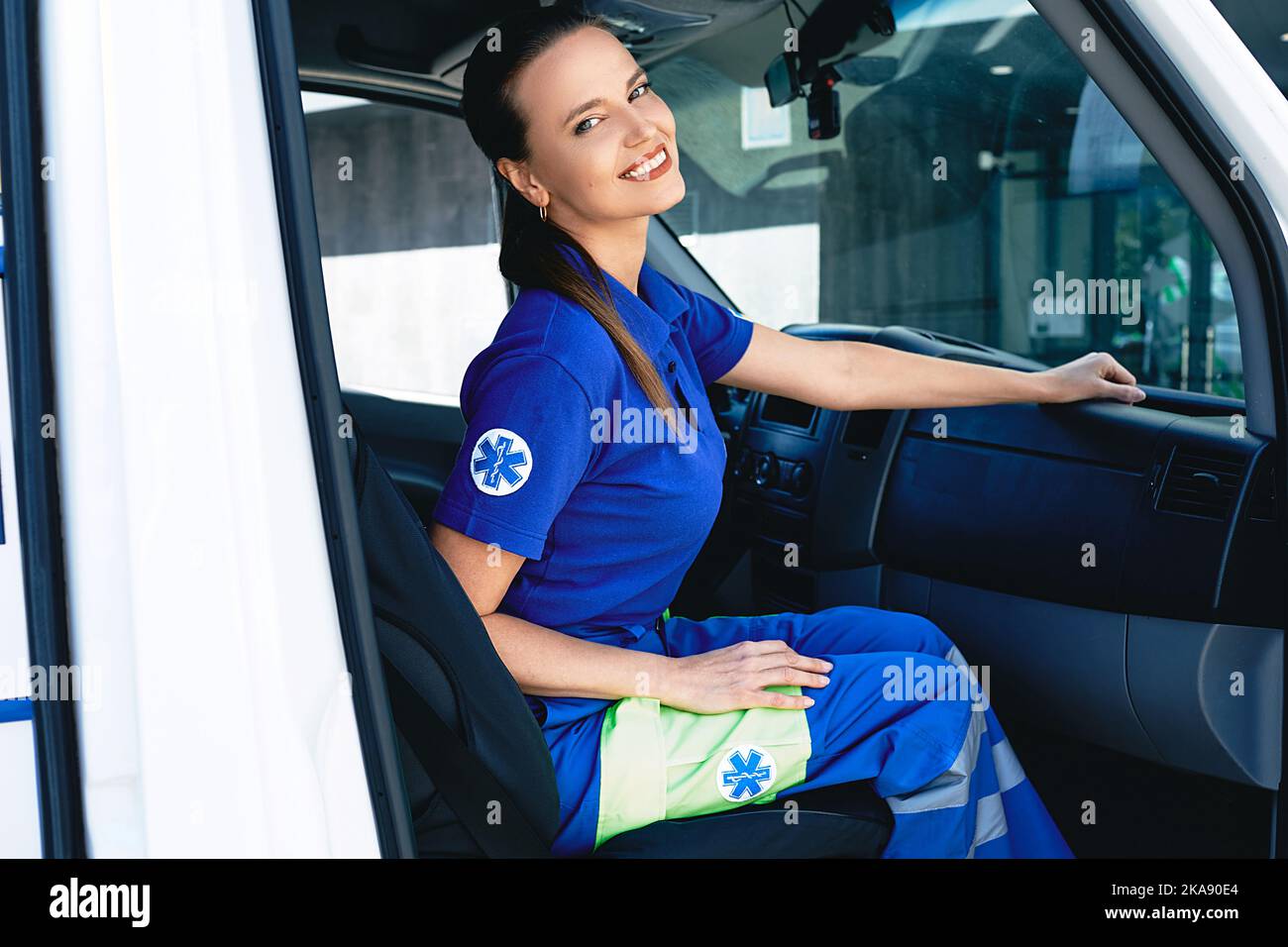 Travailleur des services médicaux d'urgence. Portrait d'une femme ambulancier assise dans une ambulance Banque D'Images