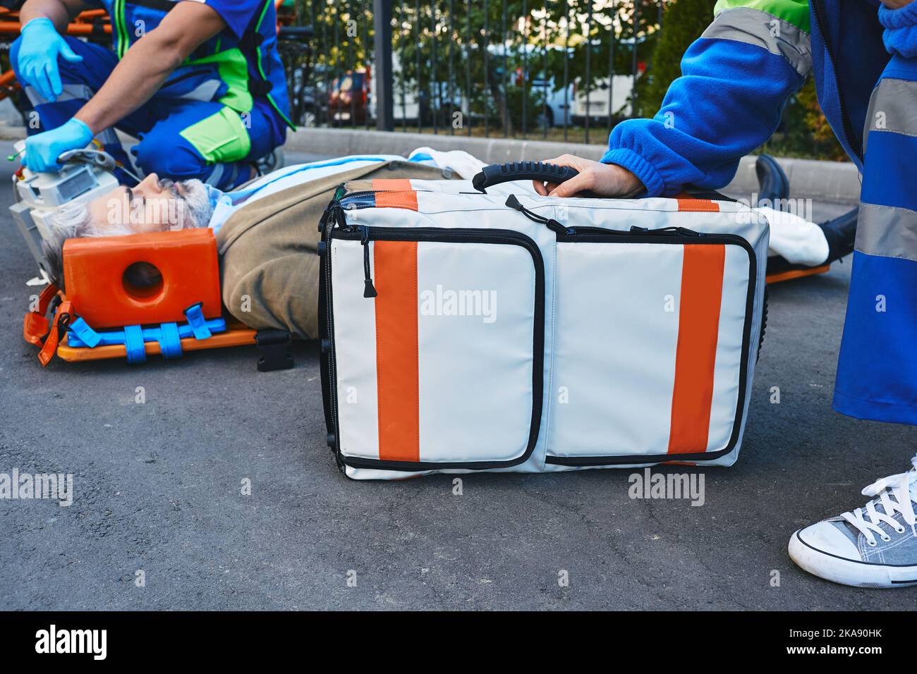 Premiers soins des ambulanciers à un patient inconscient blessé. Techniciens médicaux d'urgence Banque D'Images