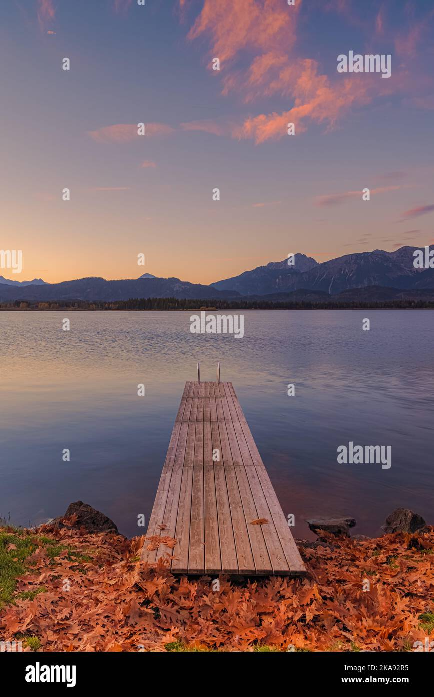 Lever de soleil en automne avec une jetée au lac Hopfen avec les Alpes Allgauer en arrière-plan, en Bavière, dans le sud de l'Allemagne. Banque D'Images