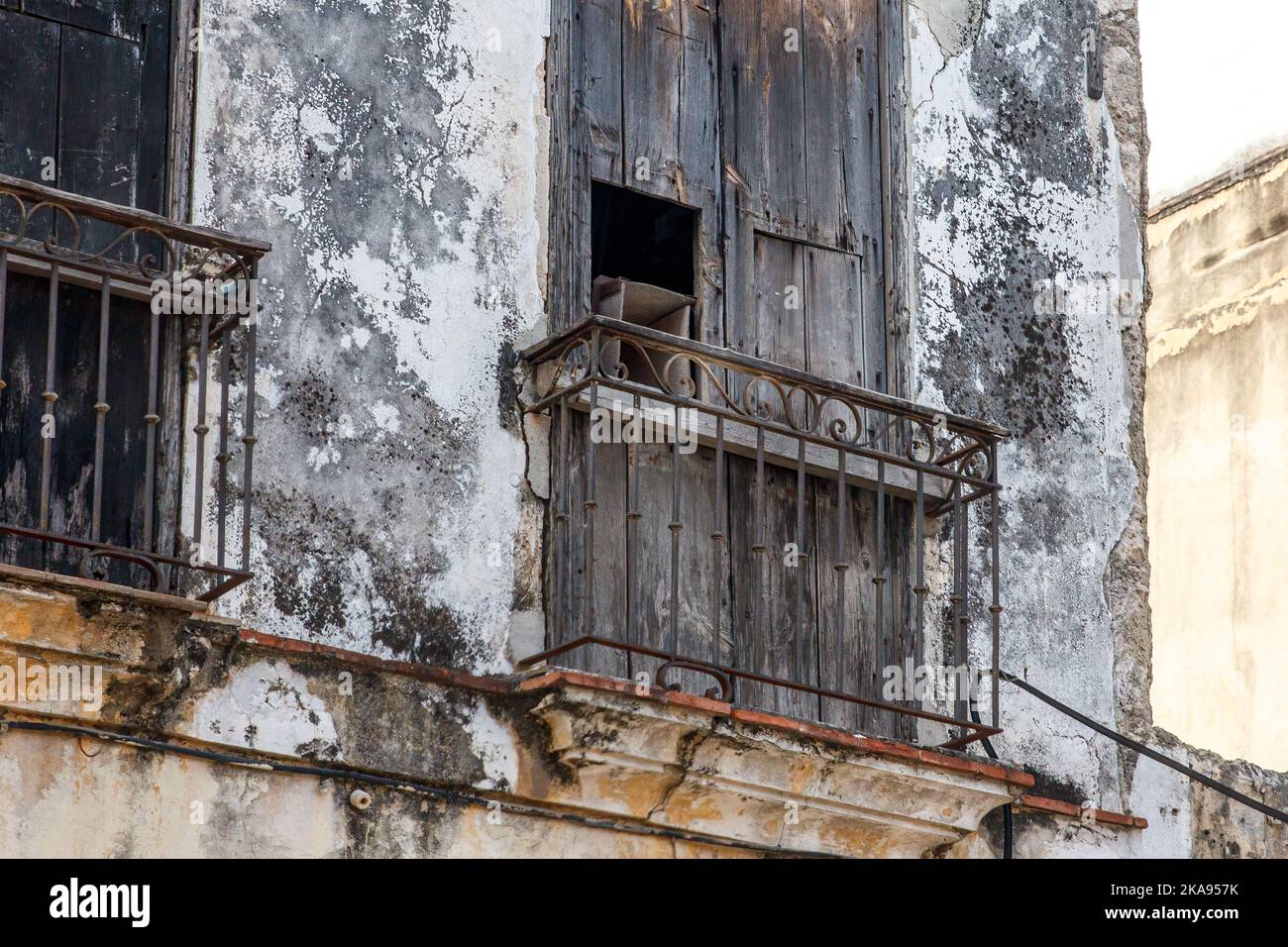 Un mur à l'eau avec une porte vitrée en bois. La rampe est rouillée. Banque D'Images