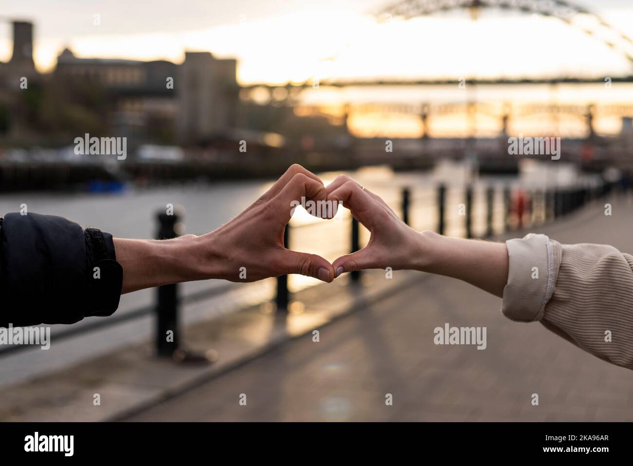 Un couple méconnaissable passe la journée ensemble à Newcastle upon Tyne. Ils mettent leurs mains ensemble et créent une forme de coeur. Banque D'Images