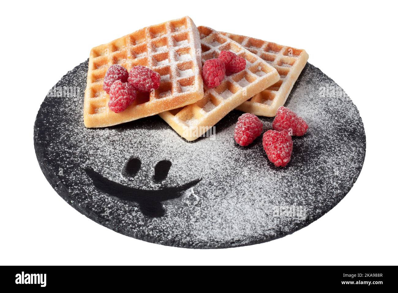 Gaufres maison avec baies et sucre en poudre sur plaque de pierre noire isolée. Gaufre belge avec framboise sur fond blanc Banque D'Images