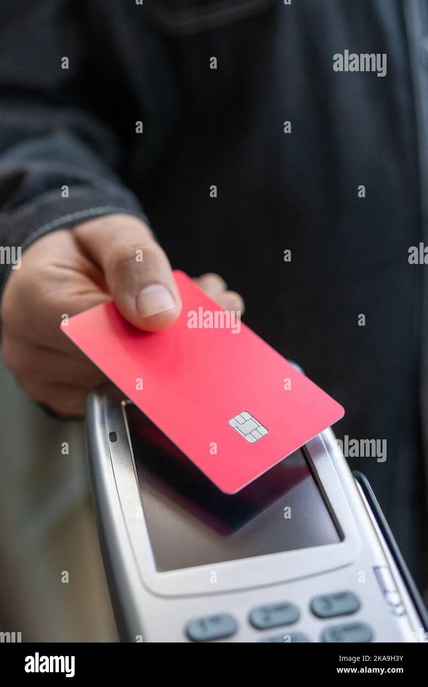 Client payant avec lecteur de carte de crédit dans un magasin Banque D'Images