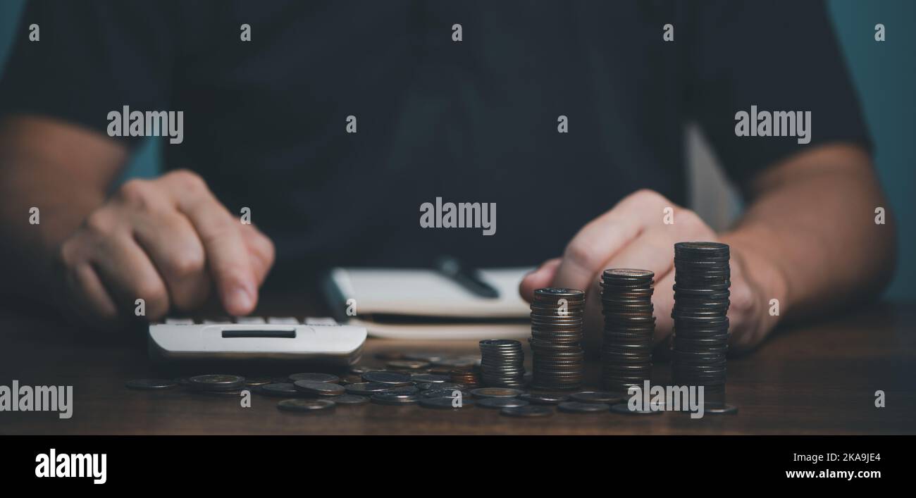 Homme main tenant la pièce d'argent sur bois en table, économiser de l'argent richesse et concept financier, Affaires, finance, investissement, planification financière. Banque D'Images