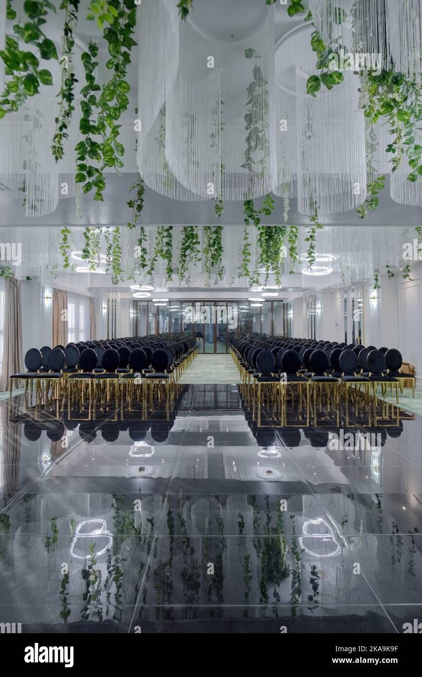 Salle de conférence de l'hôtel avec chaises vides, design vert avec plantes vertes et fleurs. Banque D'Images