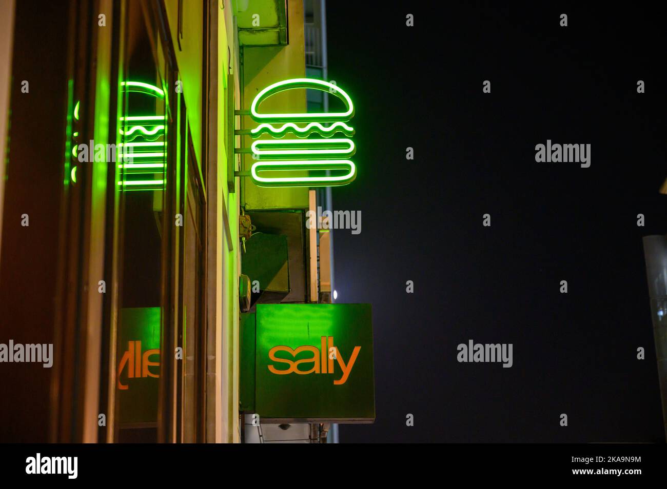 LONDRES - 2 novembre 2020 : l'enseigne de hamburger au néon Shake Shack au-dessus de l'enseigne Sally Beauty Store sur New Oxford Street la nuit Banque D'Images