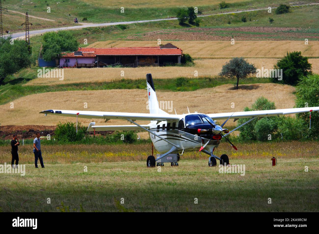 Avion blanc garé sur l'herbe dans une journée ensoleillée à l'extérieur Banque D'Images