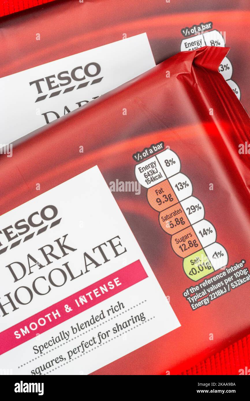 Gros plan sur les emballages alimentaires en film plastique doux au chocolat noir de marque Tesco avec boîte lumineuse alimentaire à teneur en matières grasses alimentaires et teneur élevée en sucre. Banque D'Images