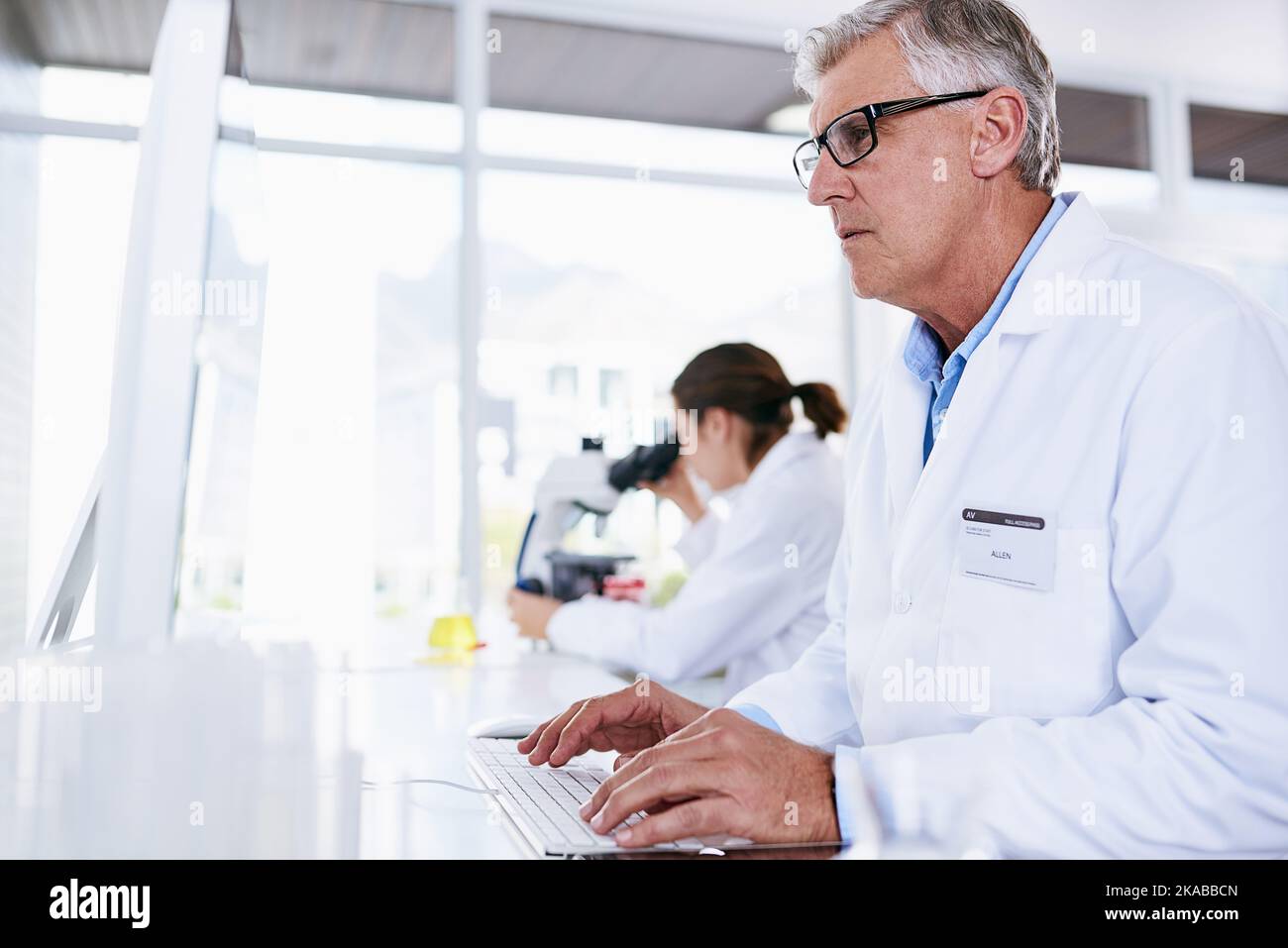 Enregistrement de nouveaux résultats dans le système. Un scientifique mature travaillant sur un ordinateur dans un laboratoire. Banque D'Images