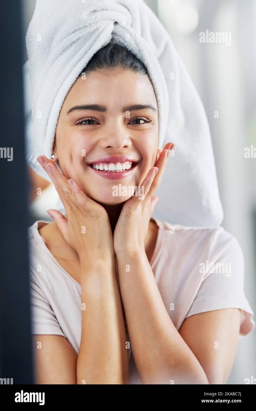 Oh quelle belle peau que j'ai. Une belle jeune femme qui admirait sa peau dans le miroir à la maison. Banque D'Images