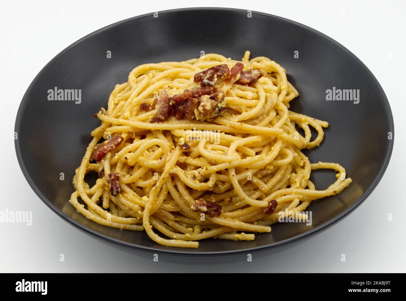 Spaghetti italiens alla Carbonara pâtes dans un plat noir isolé sur blanc. Banque D'Images