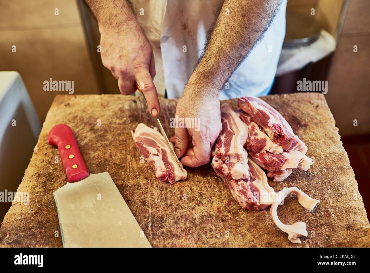 Des tranches parfaites pour mes grands clients. Un boucher à son magasin. Banque D'Images