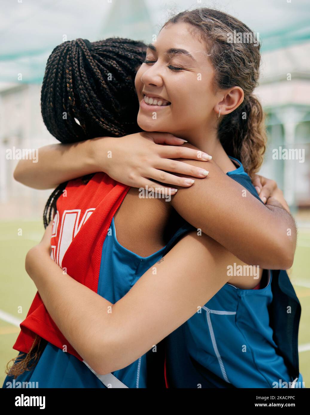 Match de sport, de hug et de fille étudiante montrant le soutien, la confiance et le travail d'équipe sur un terrain extérieur. Étudiant de football ou joueur de netball avec un sourire heureux Banque D'Images