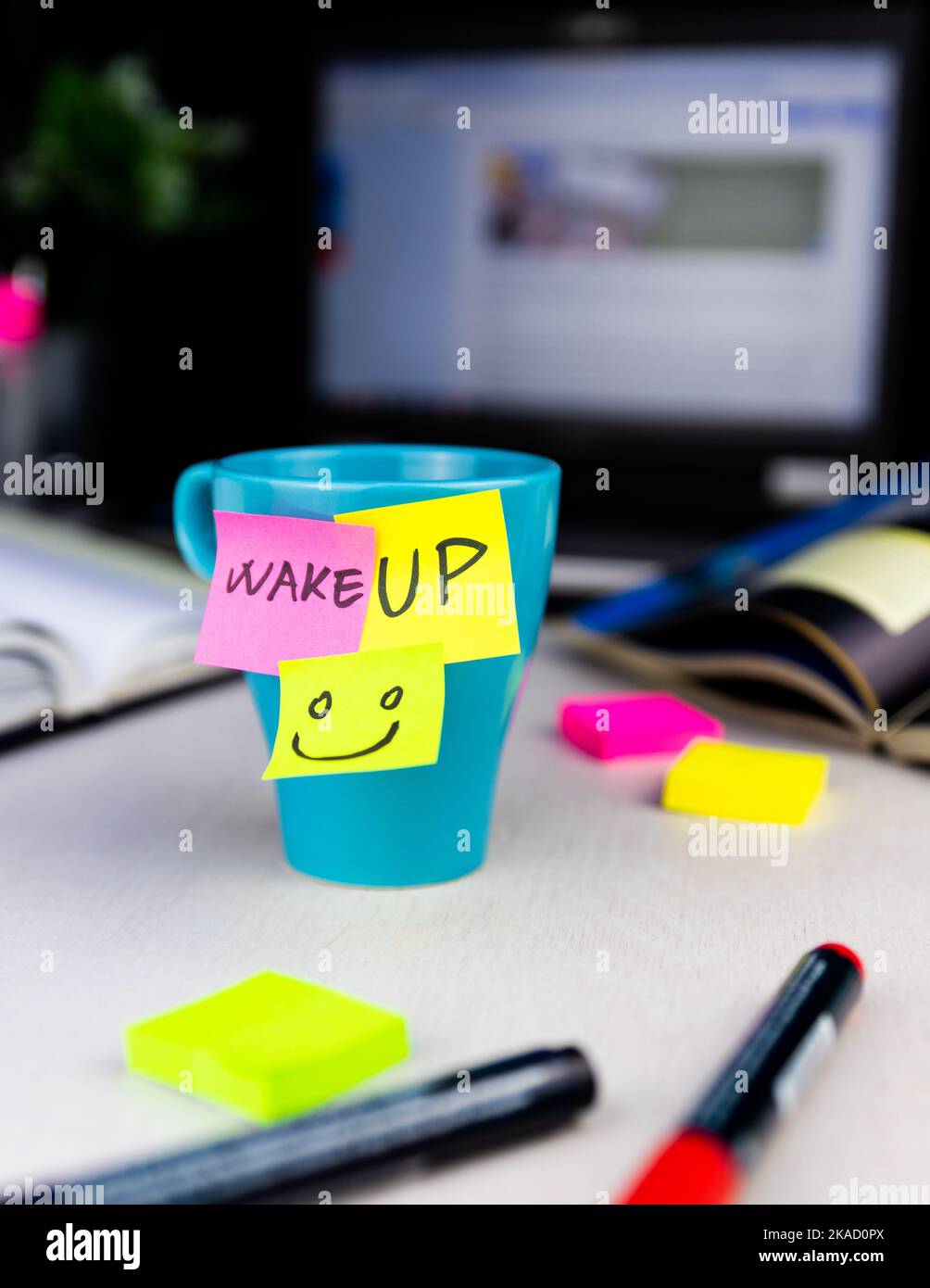 Des notes adhésives sur une tasse à café au bureau. Réveillez-vous et souriez. Commencez votre journée par des pensées positives Banque D'Images