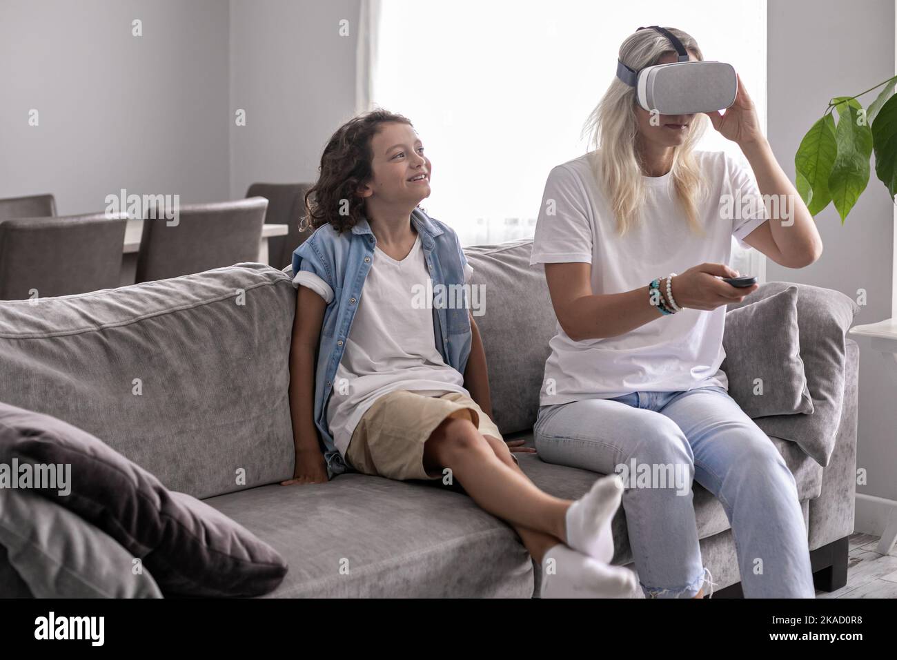 garçon enfant avec une mère portant un casque de réalité virtuelle lunettes vr dans le salon à la maison pour s'amuser Banque D'Images