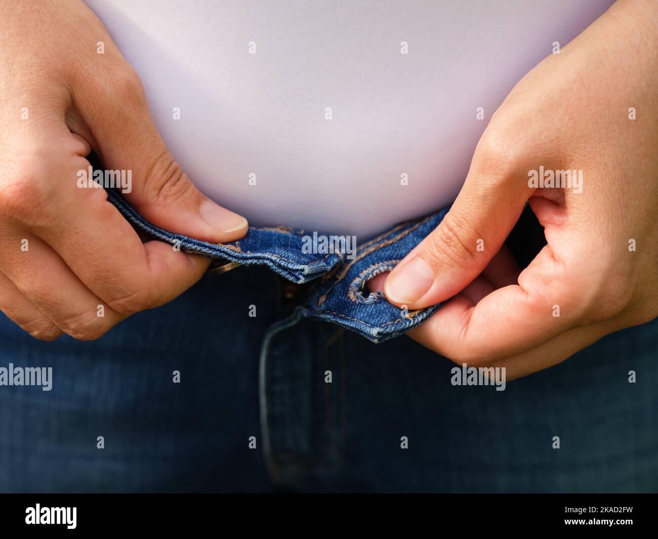 Une femme essayant de boutons jeans. Gros plan Banque D'Images