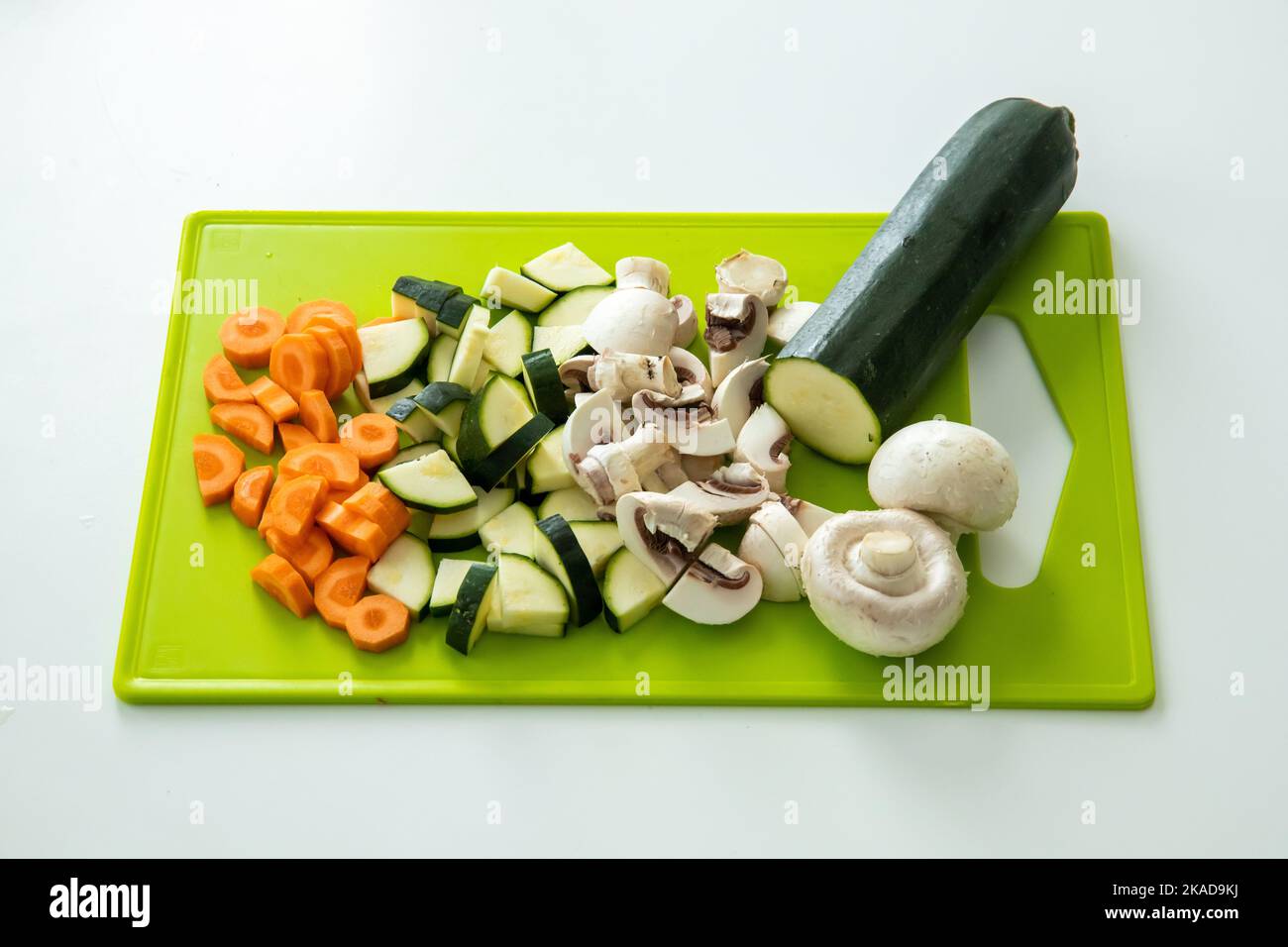 Une belle photo de courgettes hachées, de carottes et de champignons sur un tableau de cuisine vert Banque D'Images