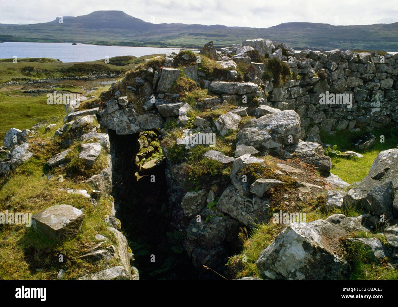 La galerie murale et les pierres de linteau de Dun Fiadhairt Iron Age broch, île de Skye, Écosse, Royaume-Uni, regardant SW sur le Loch Dunvegan aux tables de Macleod. Banque D'Images