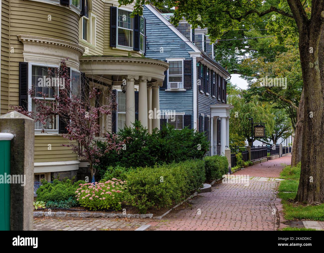 Salem, Massachusetts, États-Unis - 3 septembre 2022: Maisons et arbres avec trottoir en brique entre sur le centre-ville strest. Banque D'Images