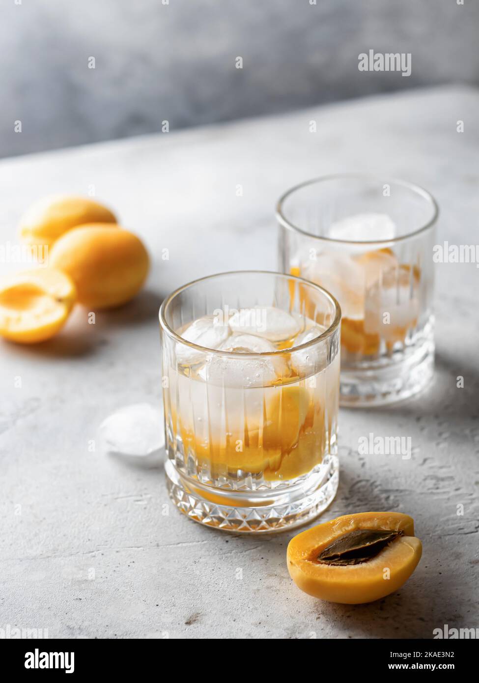 Cocktails glacés à l'abricot sur fond gris. Cocktails rafraîchissants d'été avec ou sans alcool. Eau perfusée de détox Banque D'Images