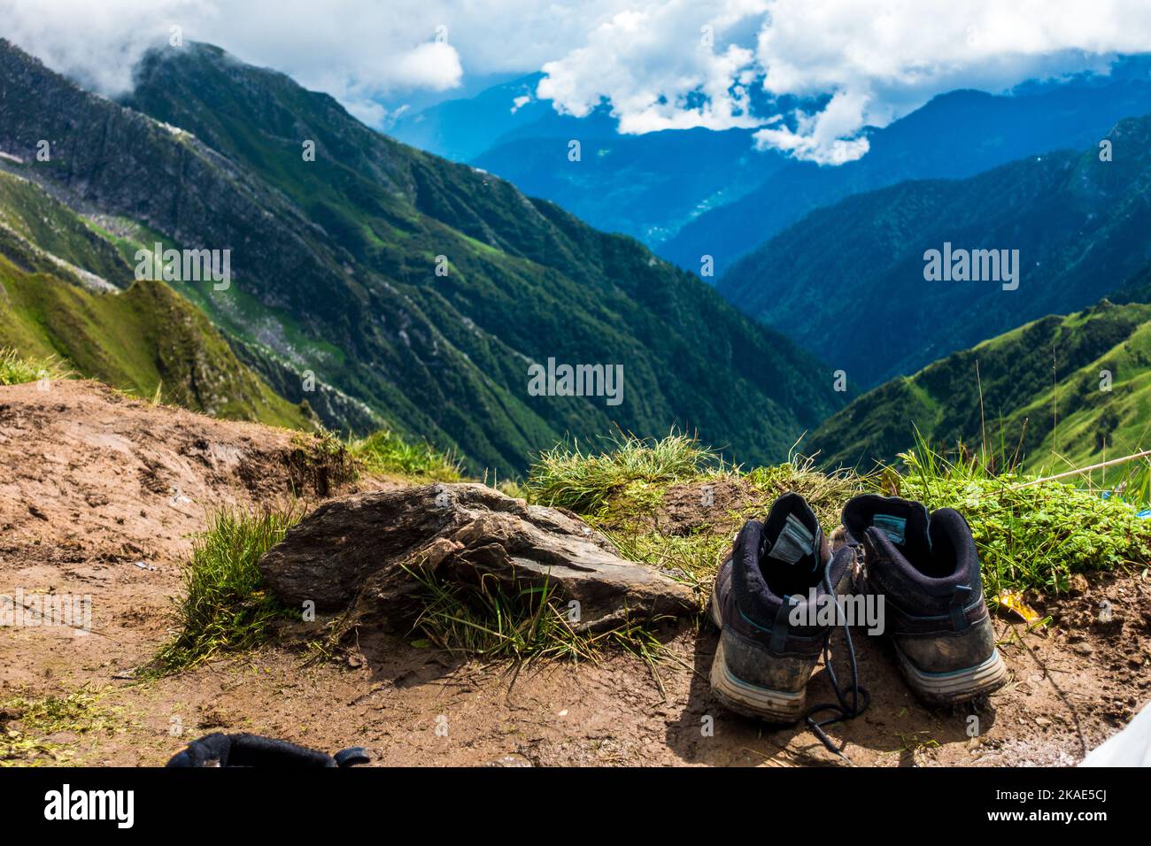 14 juillet 2022, Himachal Pradesh Inde. Paire de chaussures de randonnée et de chaussettes sur un rocher avec des paysages et le ciel en arrière-plan. Banque D'Images