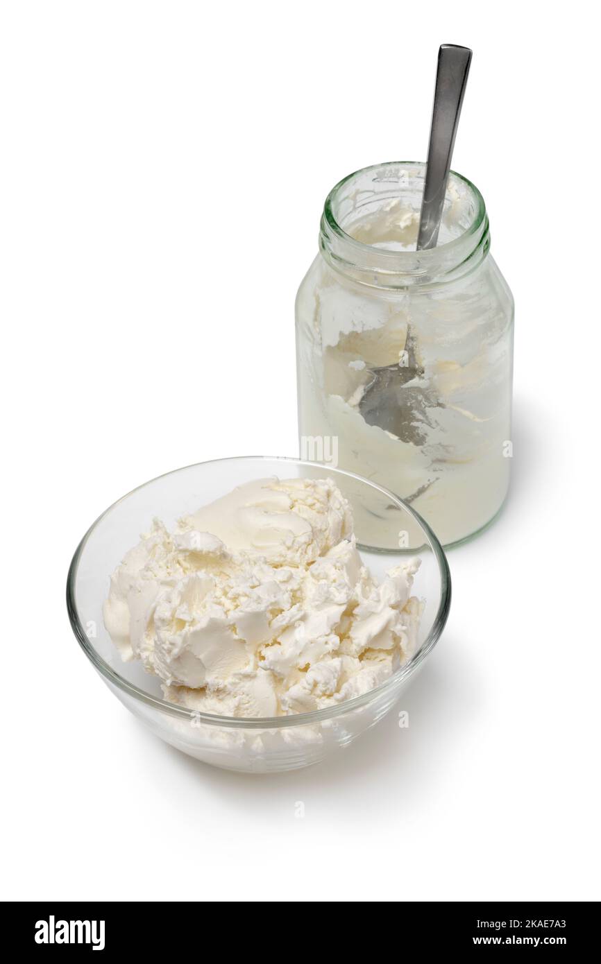 Bol et flacon en verre avec crème épaisse isolés sur fond blanc Banque D'Images