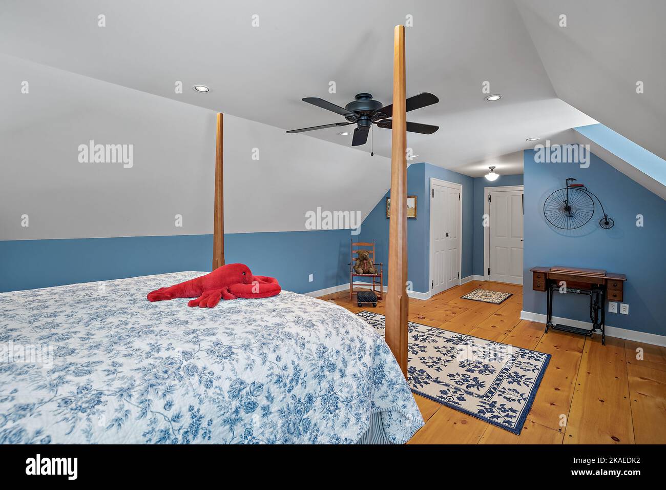 Cette chambre de style rétro est confortablement meublée et dispose d''un lit en forme de poteau et d''un ventilateur de plafond aux murs bleus Banque D'Images