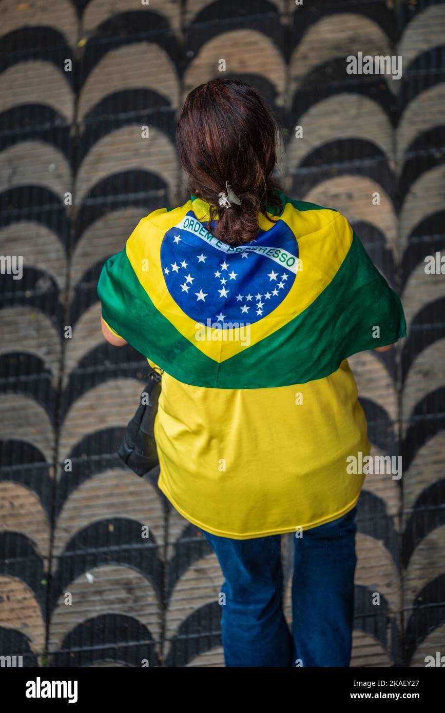 Femme portant le drapeau brésilien marchant vers une manifestation Bolsonaro à Belo Horizonte, Brésil. Banque D'Images