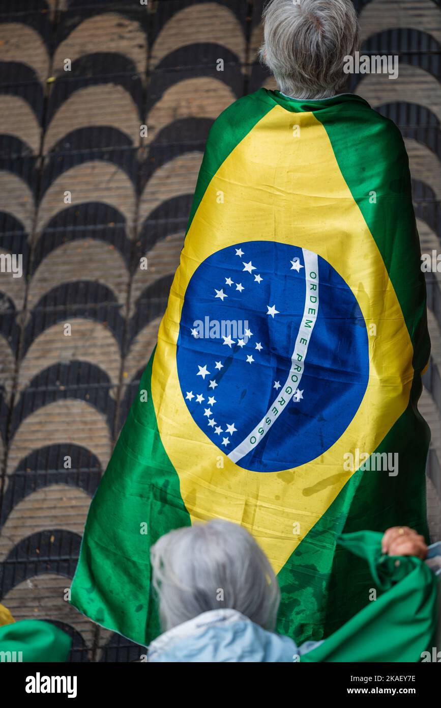Une vieille femme portant le drapeau brésilien marchant vers une manifestation Bolsonaro à Belo Horizonte, au Brésil. Banque D'Images