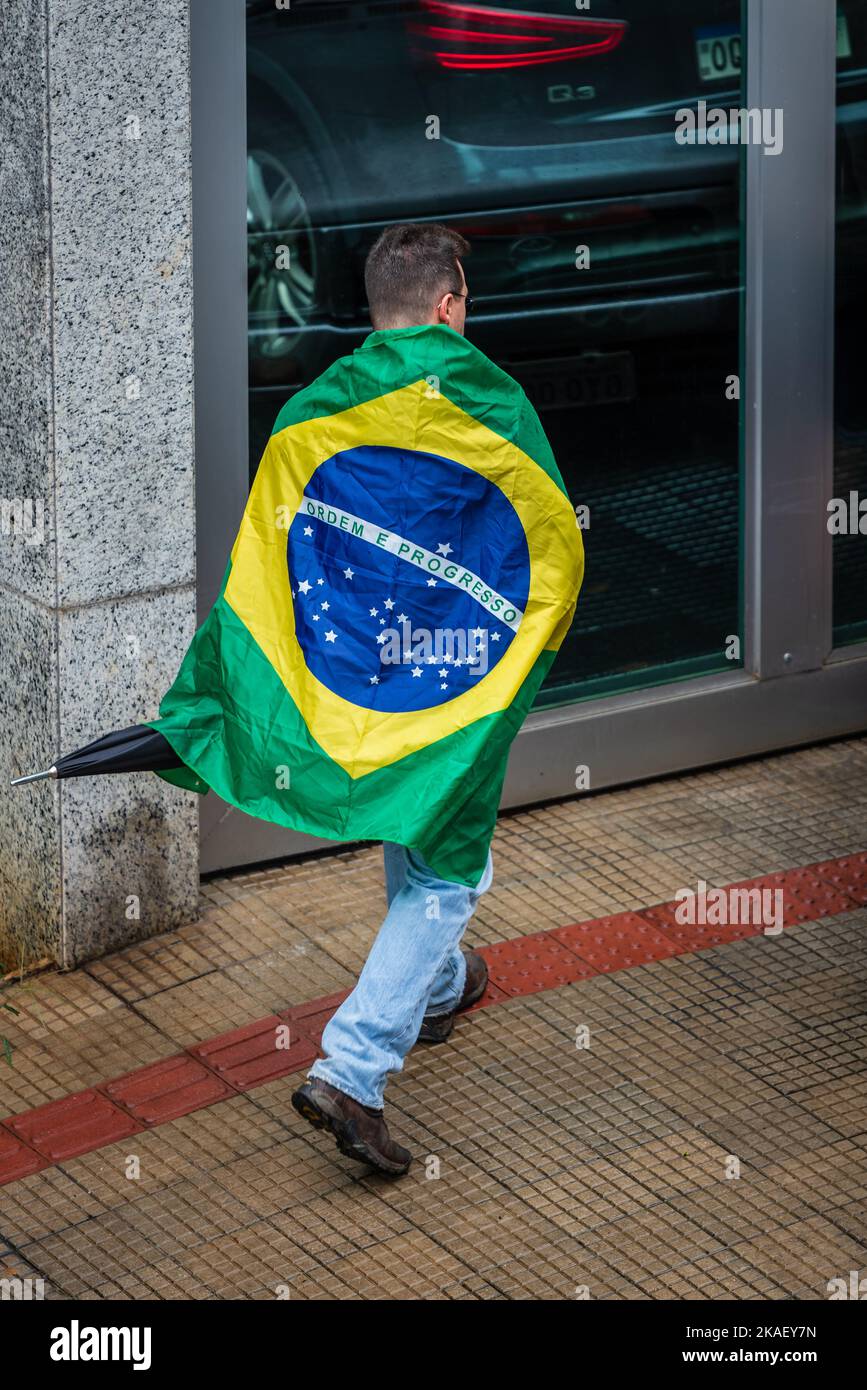 Homme portant le drapeau brésilien marchant vers une manifestation Bolsonaro à Belo Horizonte, Brésil. Banque D'Images