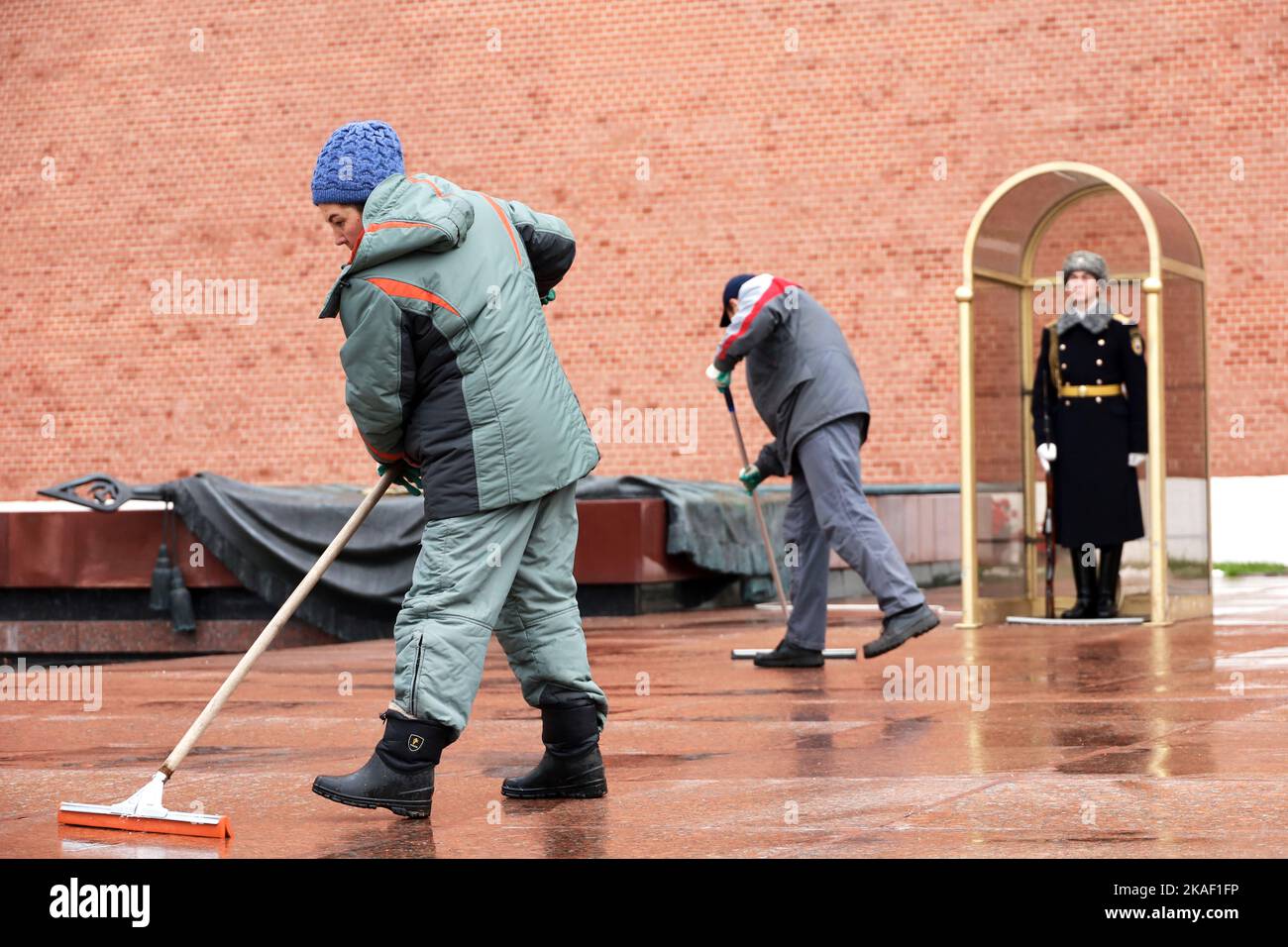 Des concierges nettoient la rue près de la tombe du Soldat inconnu sur fond de garde d'honneur près du mur du Kremlin Banque D'Images