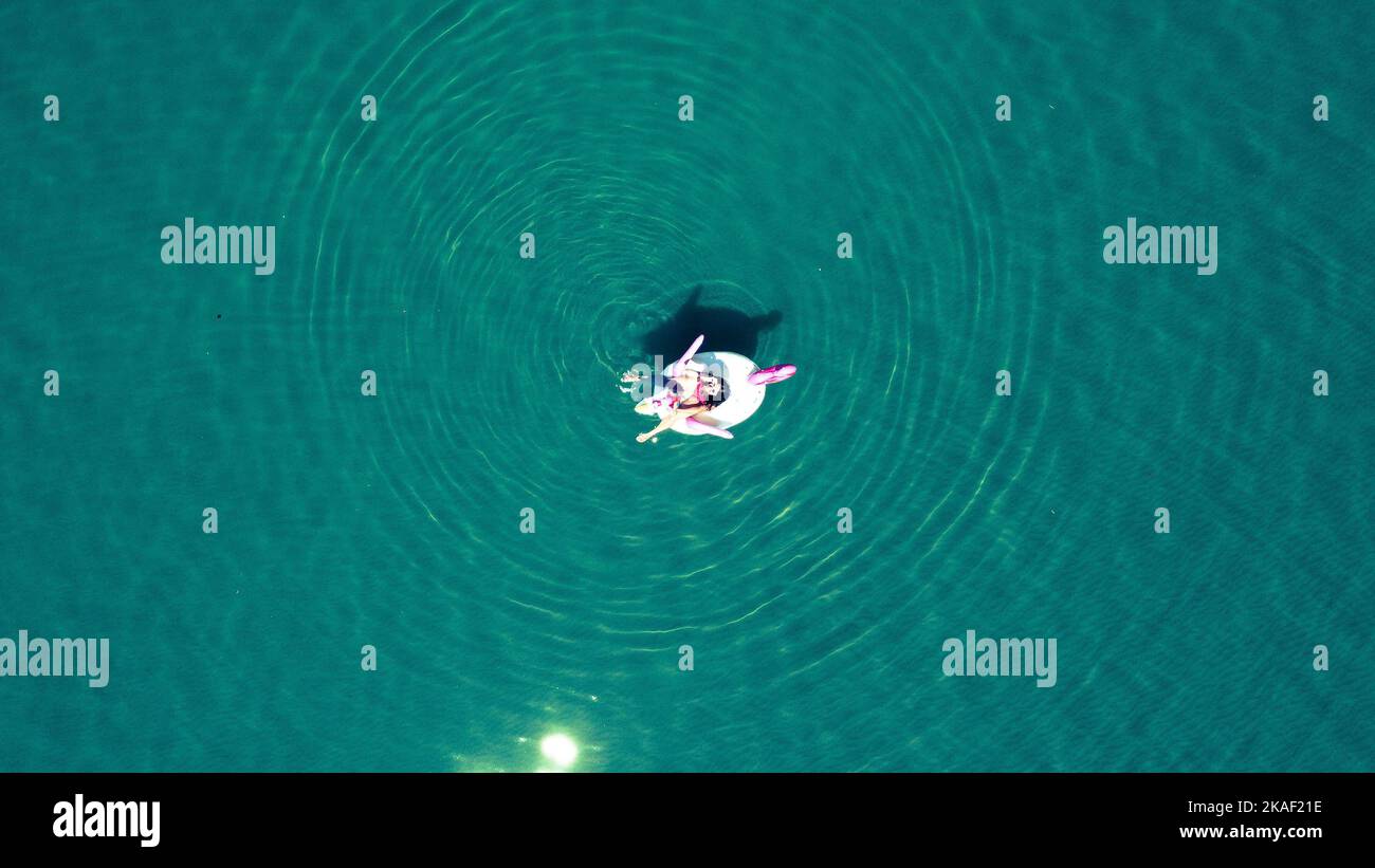 Une vue aérienne de la femme sur le flotteur gonflable de piscine d'animaux regardant vers le haut de la caméra Banque D'Images