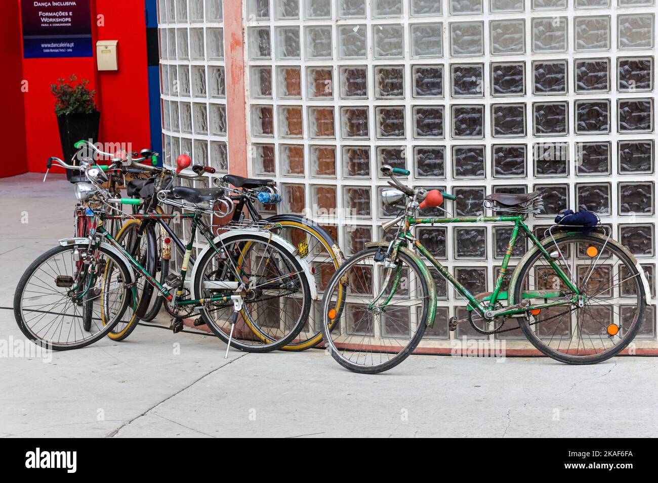 Gros plan de vélos classiques garés par un mur de verre Banque D'Images