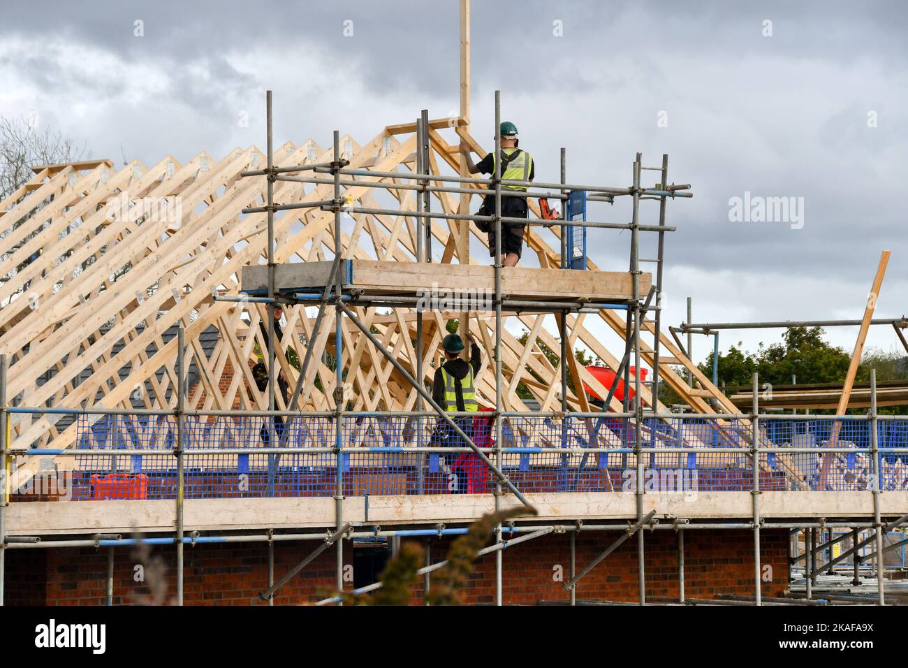 Pontypridd, pays de Galles - octobre 2022 : ouvriers de la construction travaillant sur le toit de maisons en cours de construction sur un nouveau développement de logements par Bellway Homes Banque D'Images Pontypridd, pays de Galles - octobre 2022 : ouvriers de la construction travaillant sur le toit de maisons en cours de construction sur un nouveau développement de logements par Bellway Homes Banque D'Images