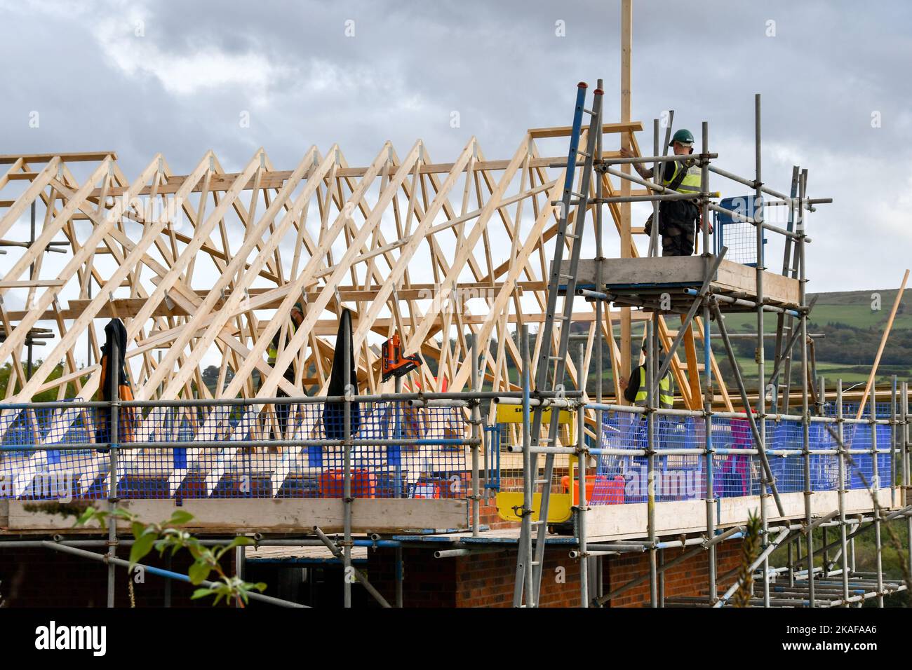 Pontypridd, pays de Galles - octobre 2022 : ouvriers de la construction travaillant sur le toit de maisons en cours de construction sur un nouveau développement de logements par Bellway Homes Banque D'Images Pontypridd, pays de Galles - octobre 2022 : ouvriers de la construction travaillant sur le toit de maisons en cours de construction sur un nouveau développement de logements par Bellway Homes Banque D'Images